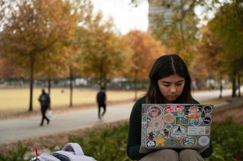 A Georgia Tech student reads outdoors.